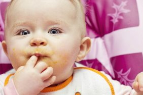 a baby feeding itself