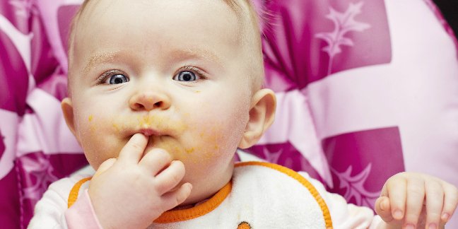 a baby feeding itself